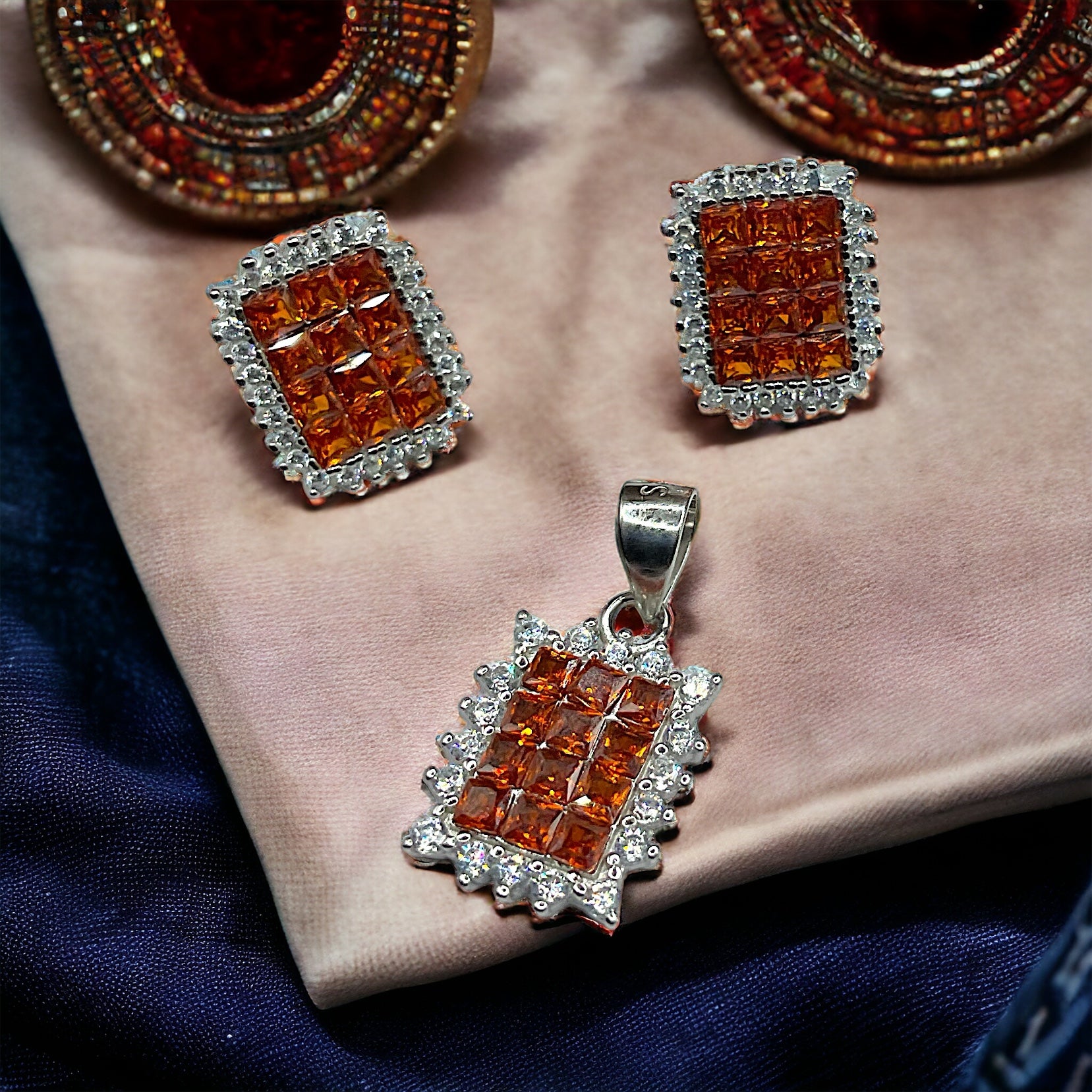 a close up of a necklace and earrings on a cloth
