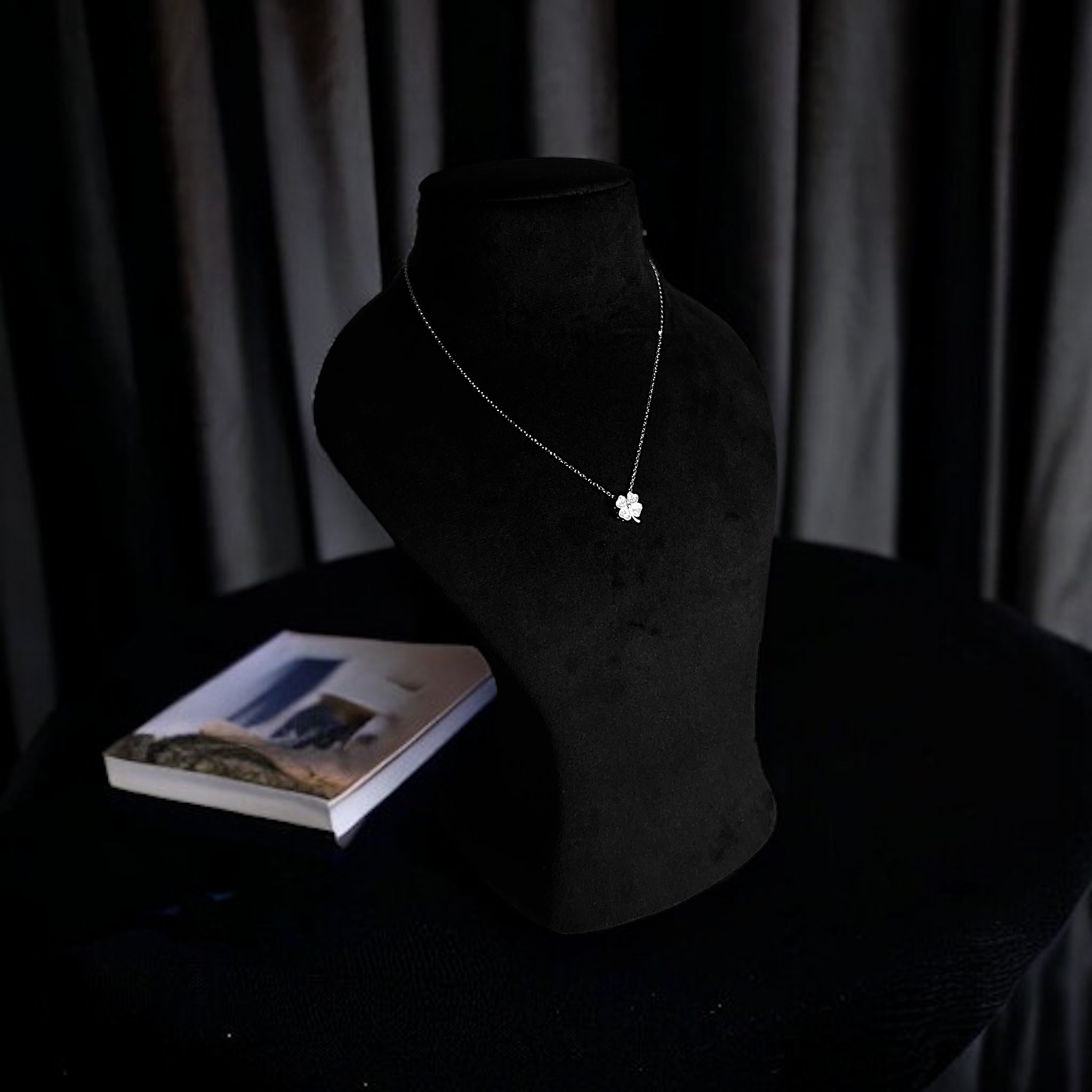 a necklace on a mannequin next to a book