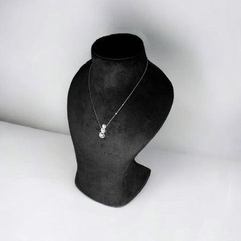 a black and white photo of a necklace on a mannequin