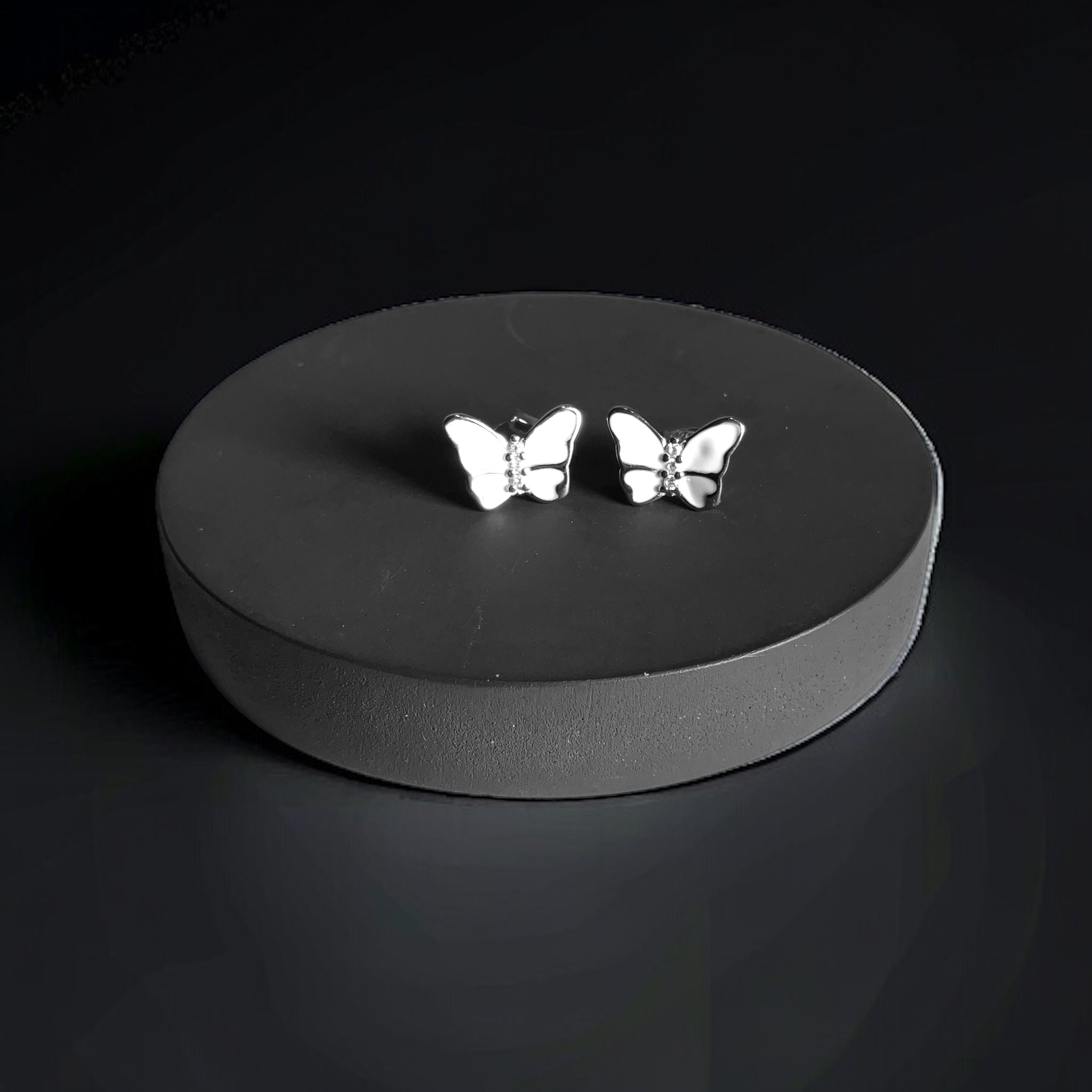 a pair of silver butterflies on a black background
