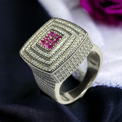 a pink diamond ring sitting on top of a white cloth