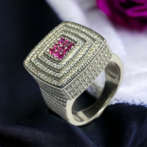 a pink diamond ring sitting on top of a white cloth