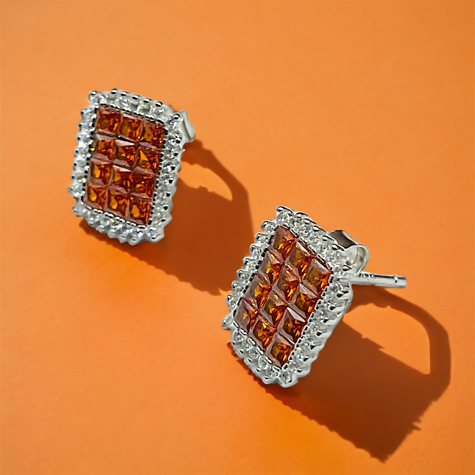 a pair of orange and white diamond earrings