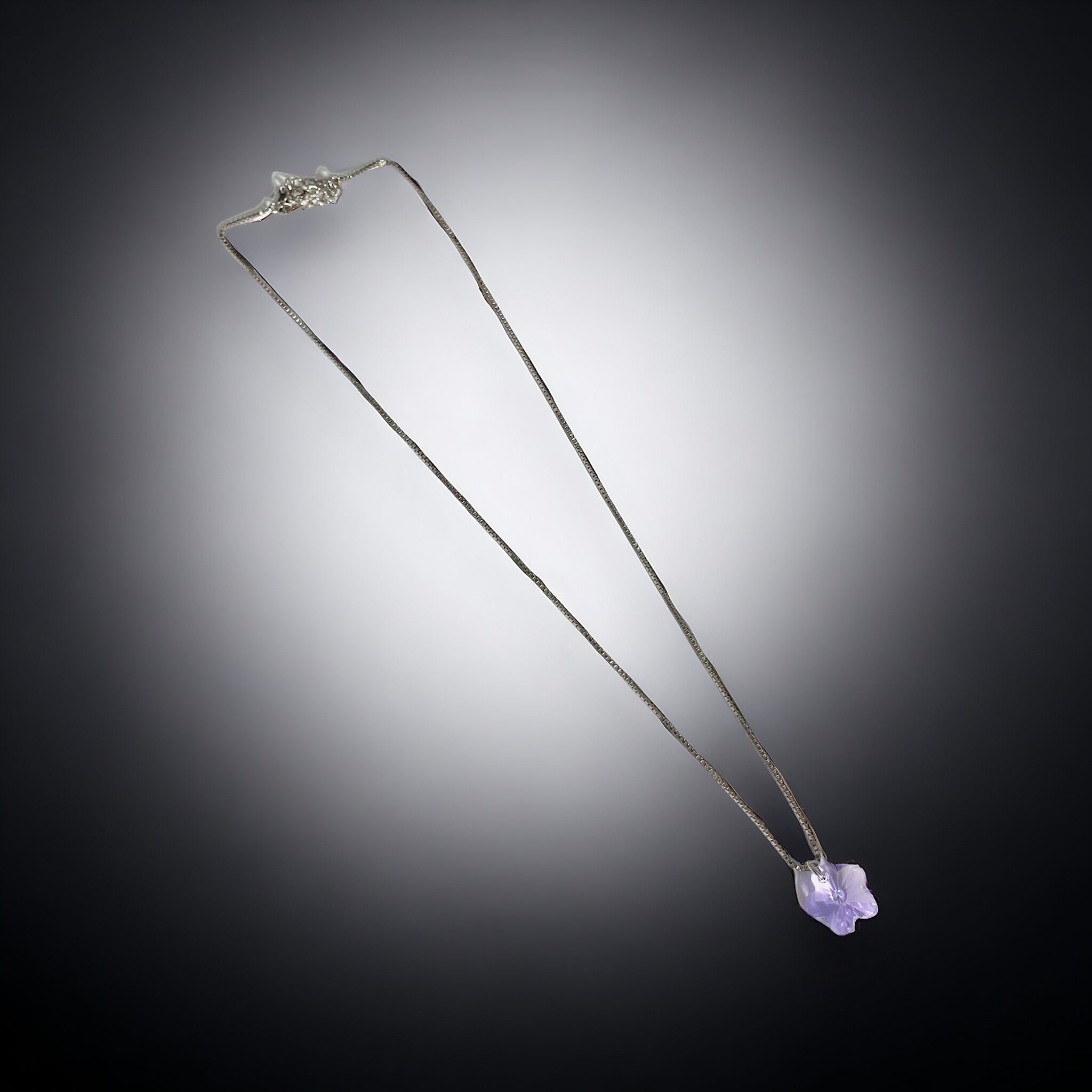 a necklace with a purple stone hanging from it