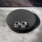 a pair of earrings sitting on top of a black box