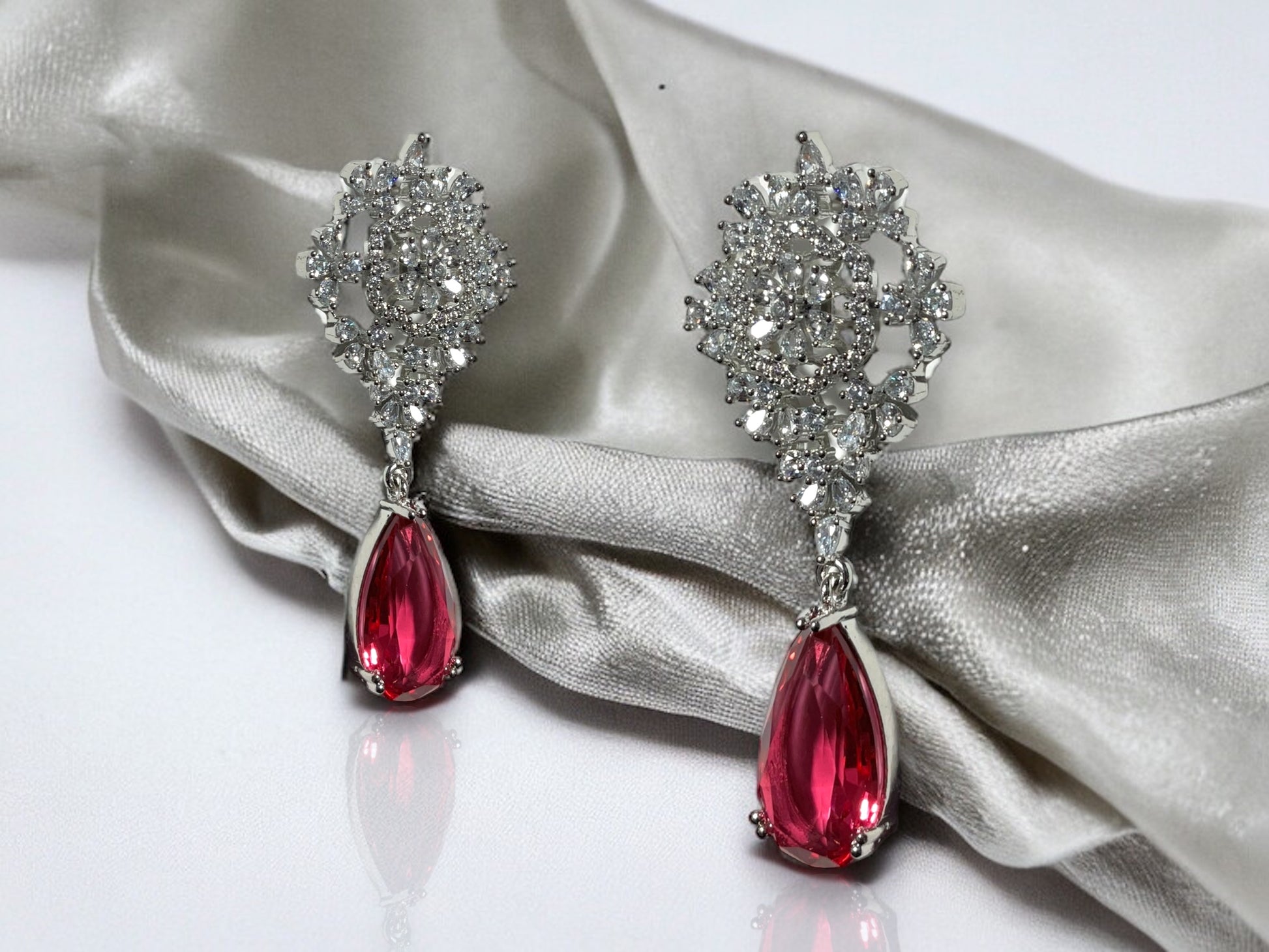 a pair of red and white diamond earrings