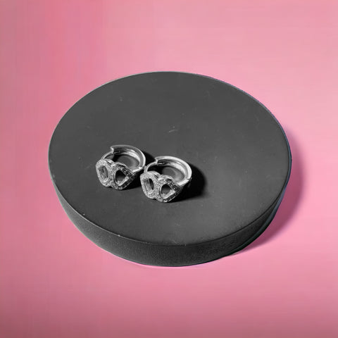a pair of skull studs sitting on top of a black box