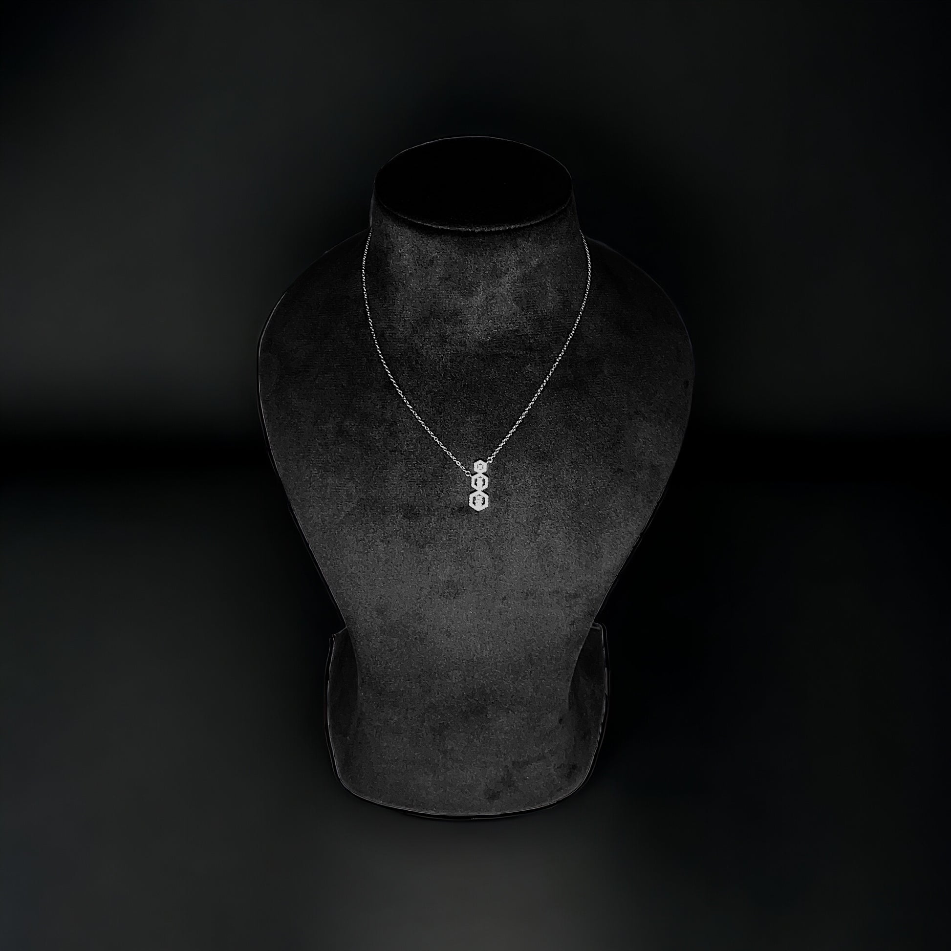 a necklace on a mannequin on a black background