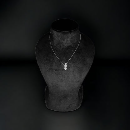 a necklace on a mannequin on a black background