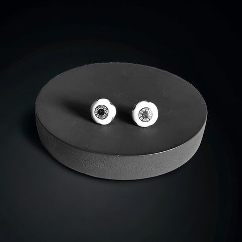 a pair of white diamond stud earrings on a black surface