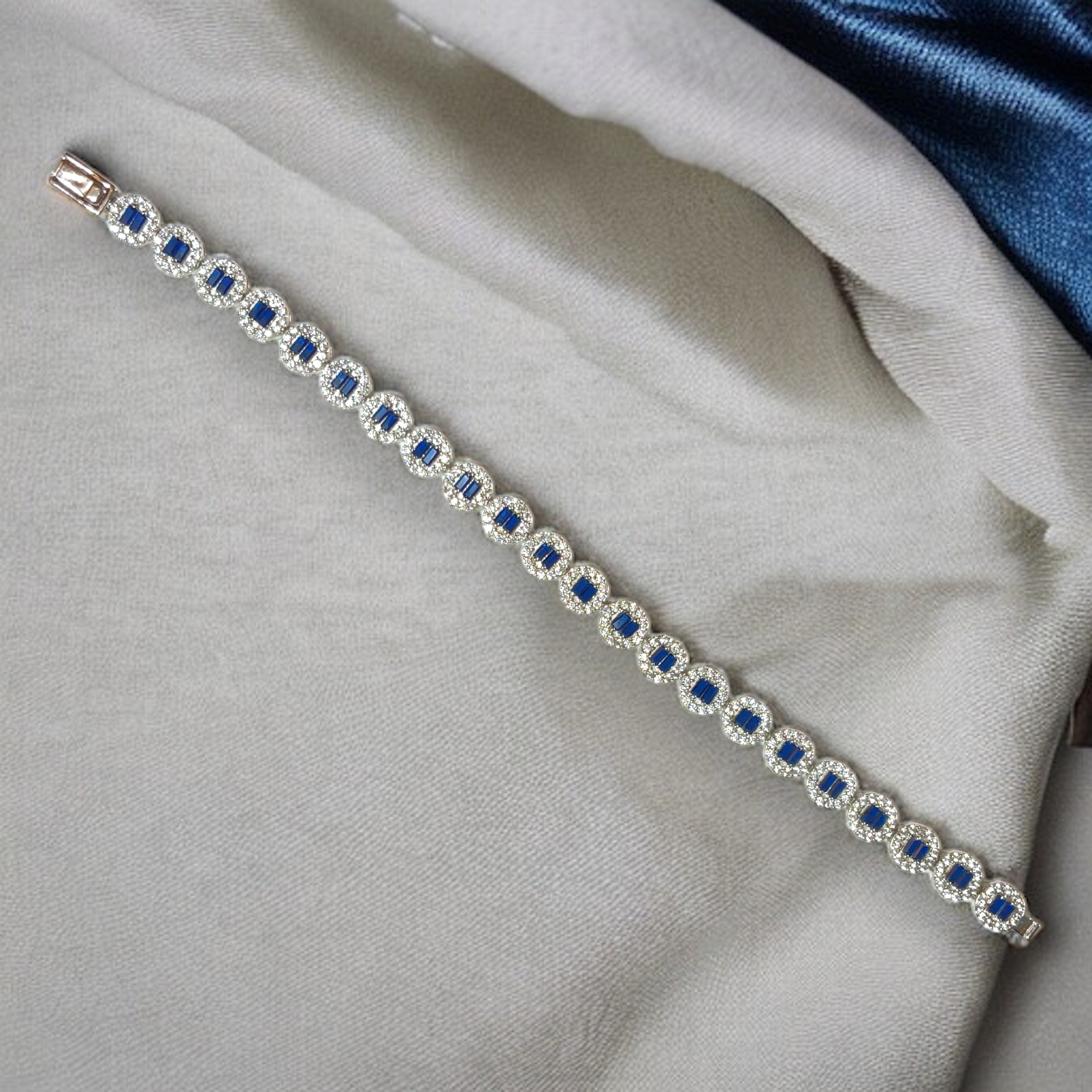 a blue and white bracelet laying on top of a white cloth