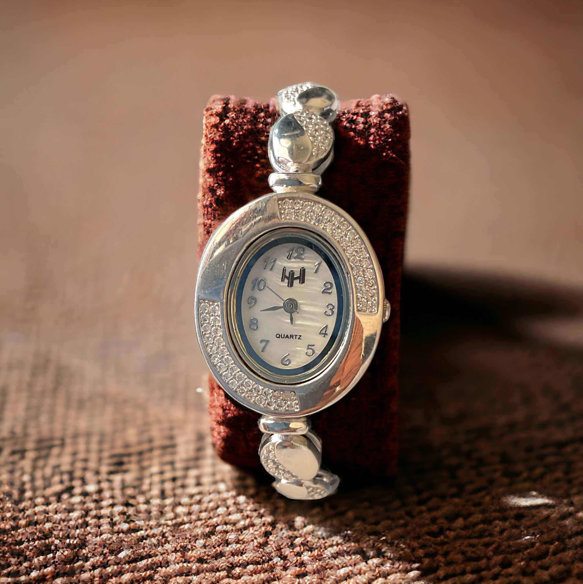 a silver watch sitting on top of a table