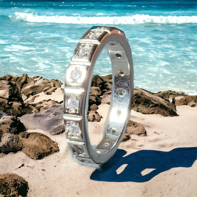 a silver ring sitting on top of a sandy beach