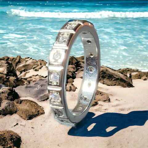 a silver ring sitting on top of a sandy beach