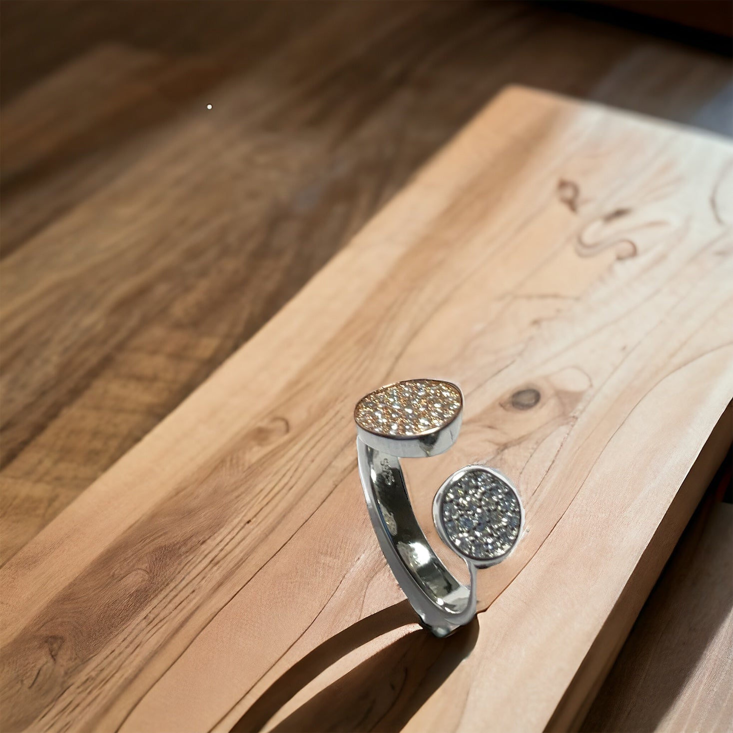 a silver ring sitting on top of a wooden table