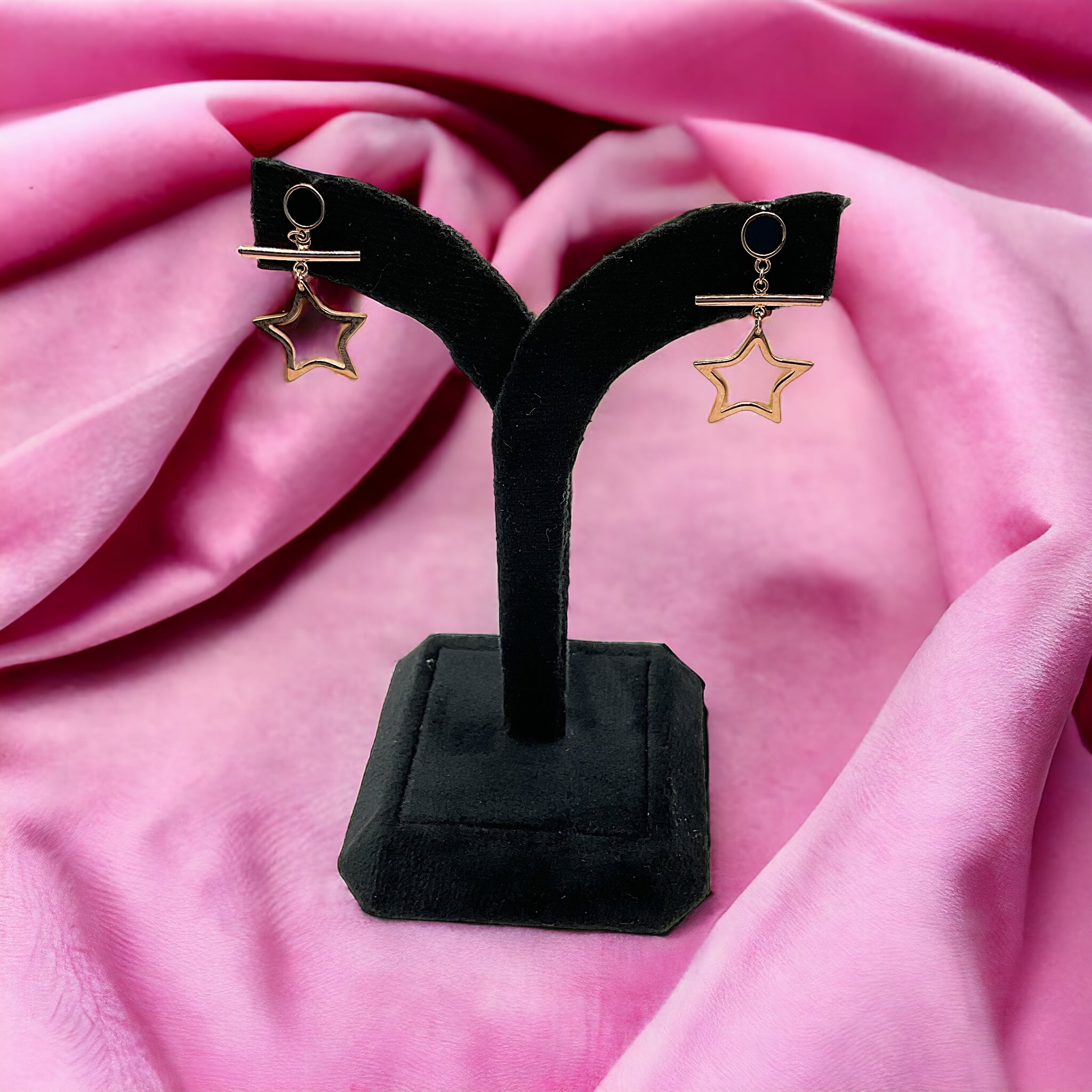 a pair of earrings on a black stand
