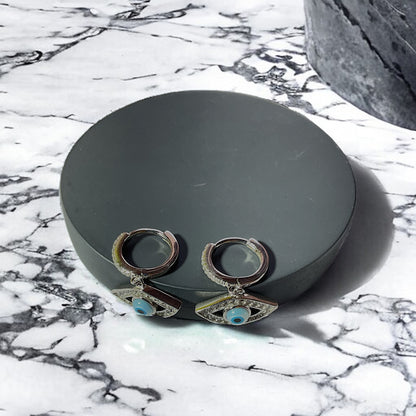 a pair of earrings sitting on top of a marble counter