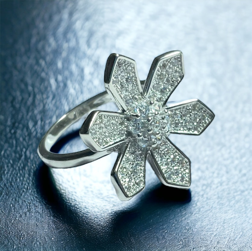 a diamond flower ring on a shiny surface
