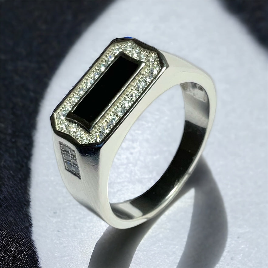 a silver ring with a black stone surrounded by diamonds