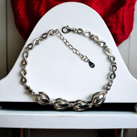 a silver chain bracelet sitting on top of a white chair