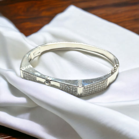 a silver bracelet sitting on top of a white cloth
