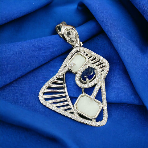 a diamond and sapphire pendant on a blue cloth