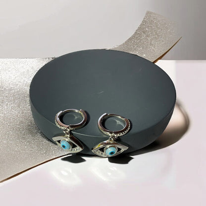 a pair of earrings sitting on top of a box