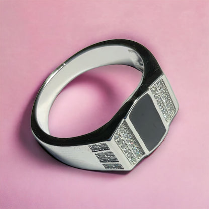 a black and white diamond ring on a pink background