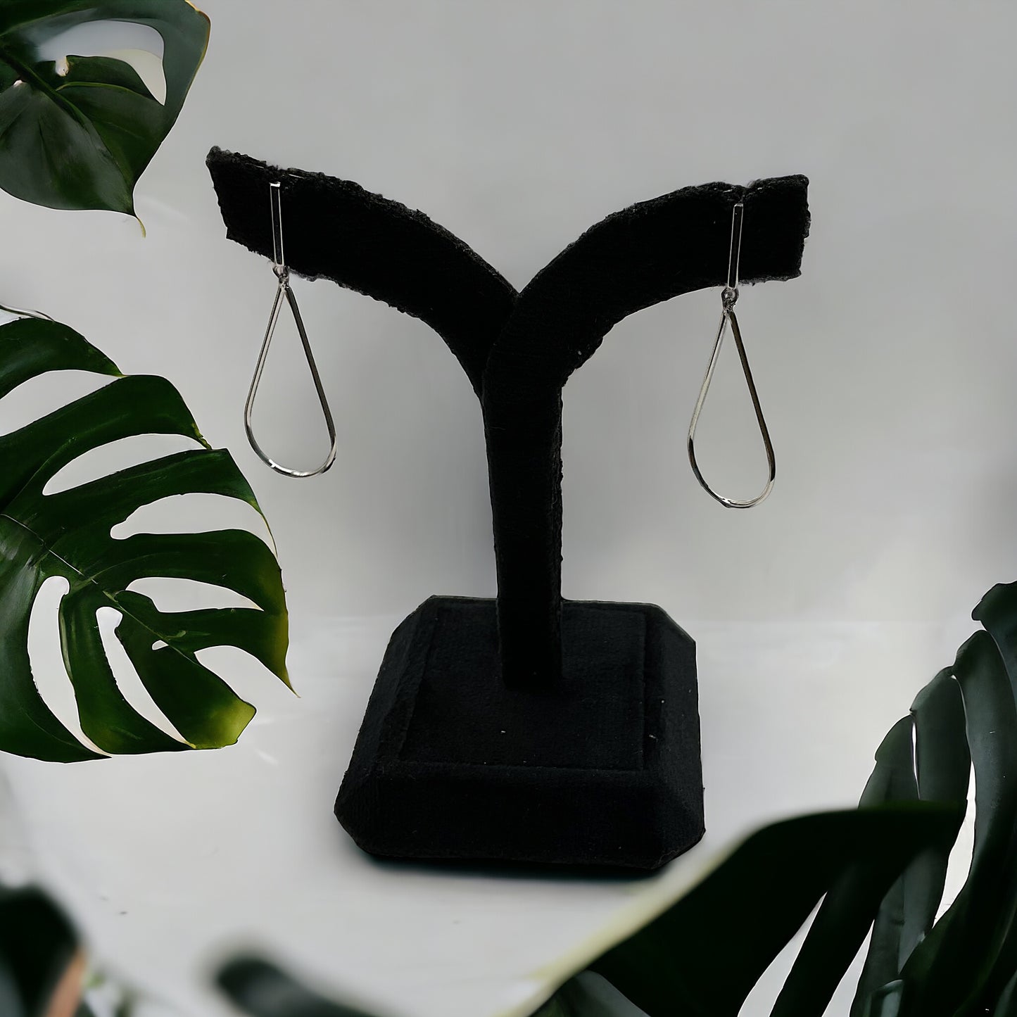 a pair of black earrings on a black stand