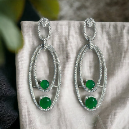 a pair of emerald and diamond earrings