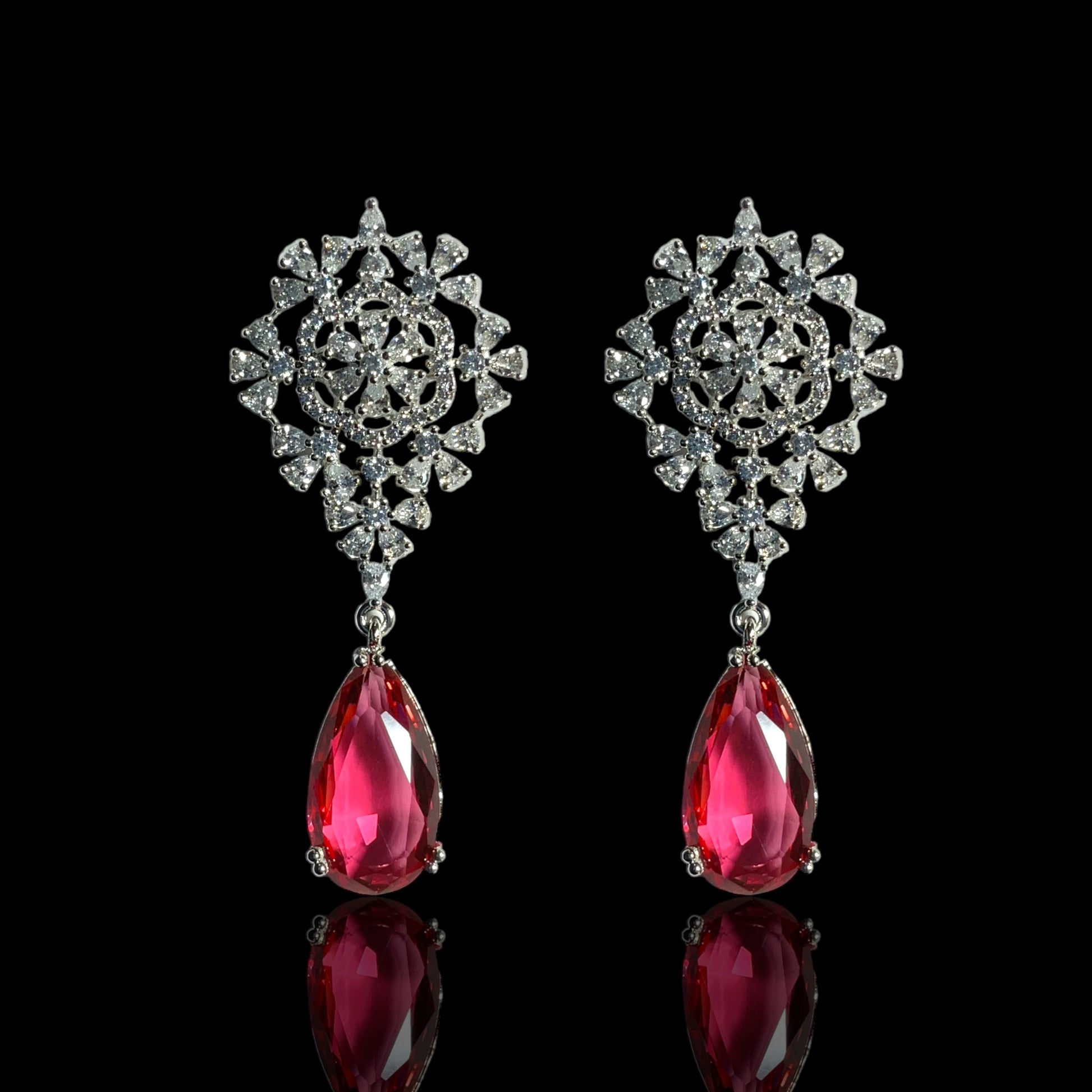 a pair of earrings with a pink stone