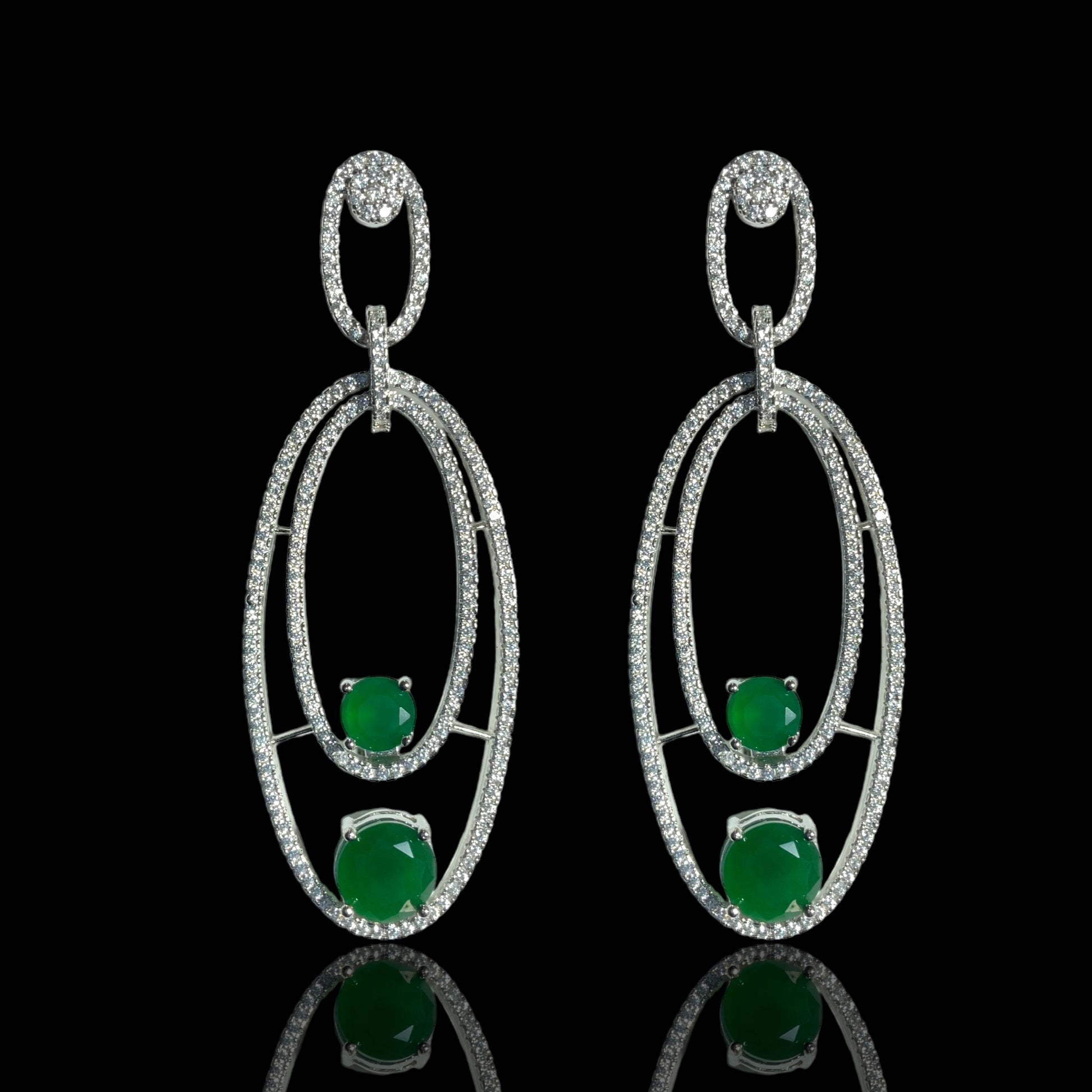 a pair of earrings with green stones and diamonds