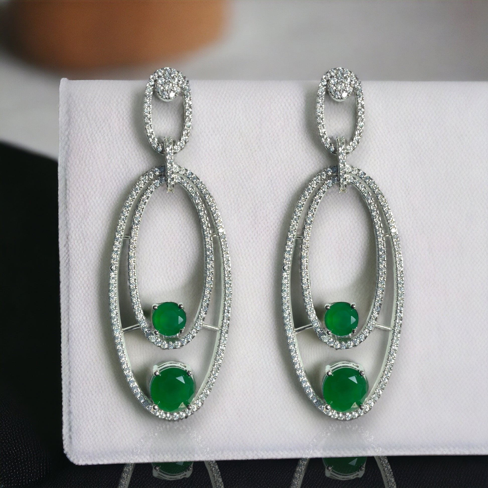 a pair of green and white stone earrings