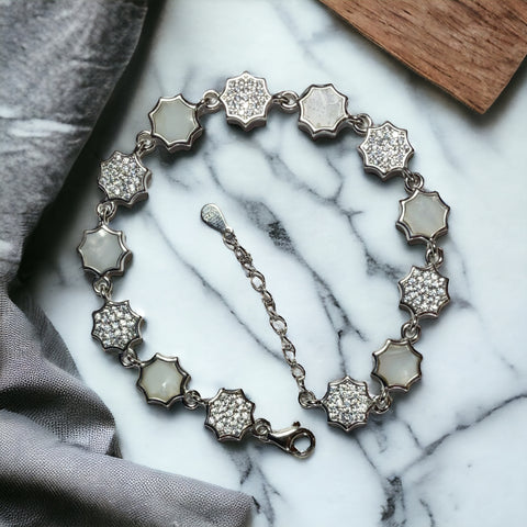 a bracelet with white stones on a marble surface