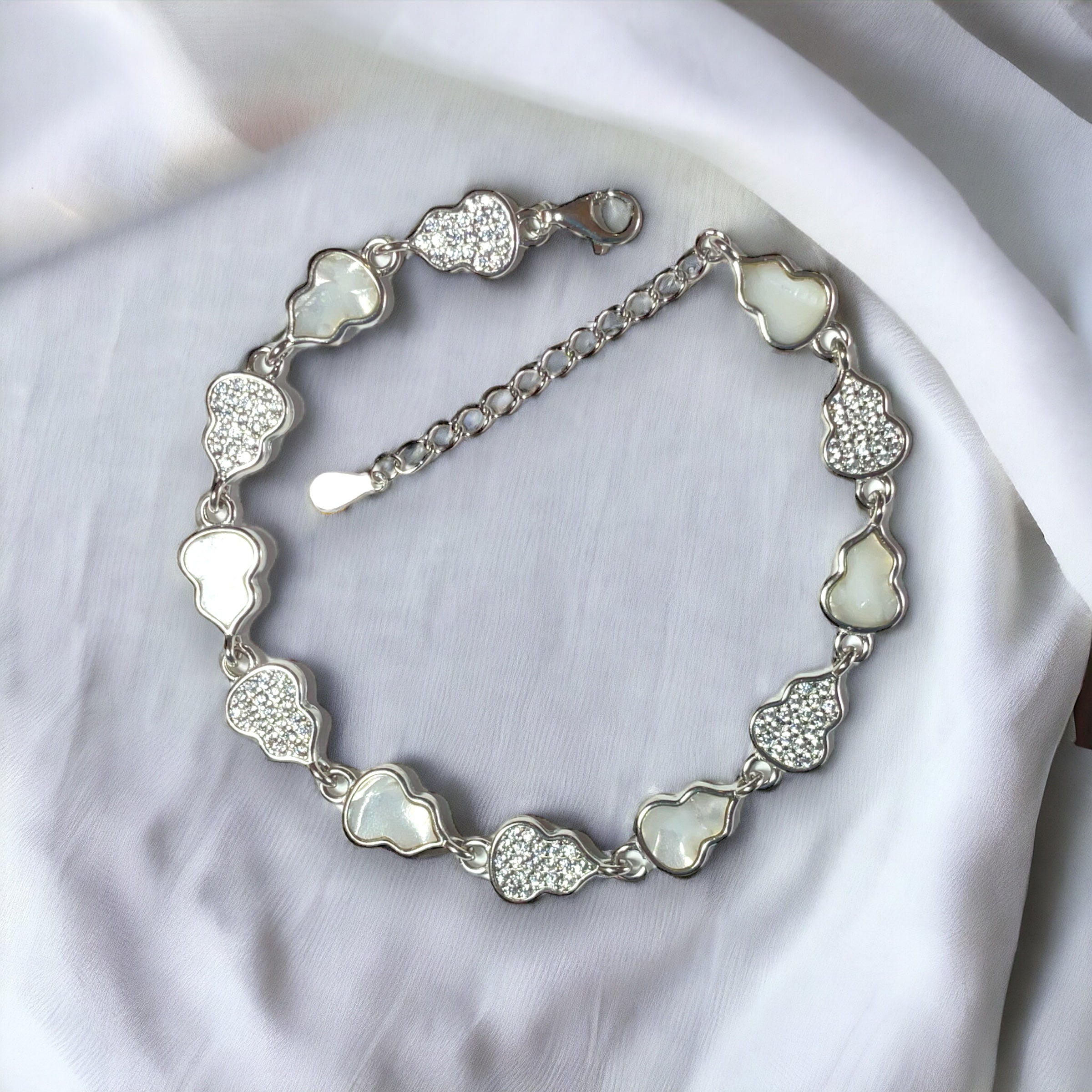 a silver bracelet with hearts on it