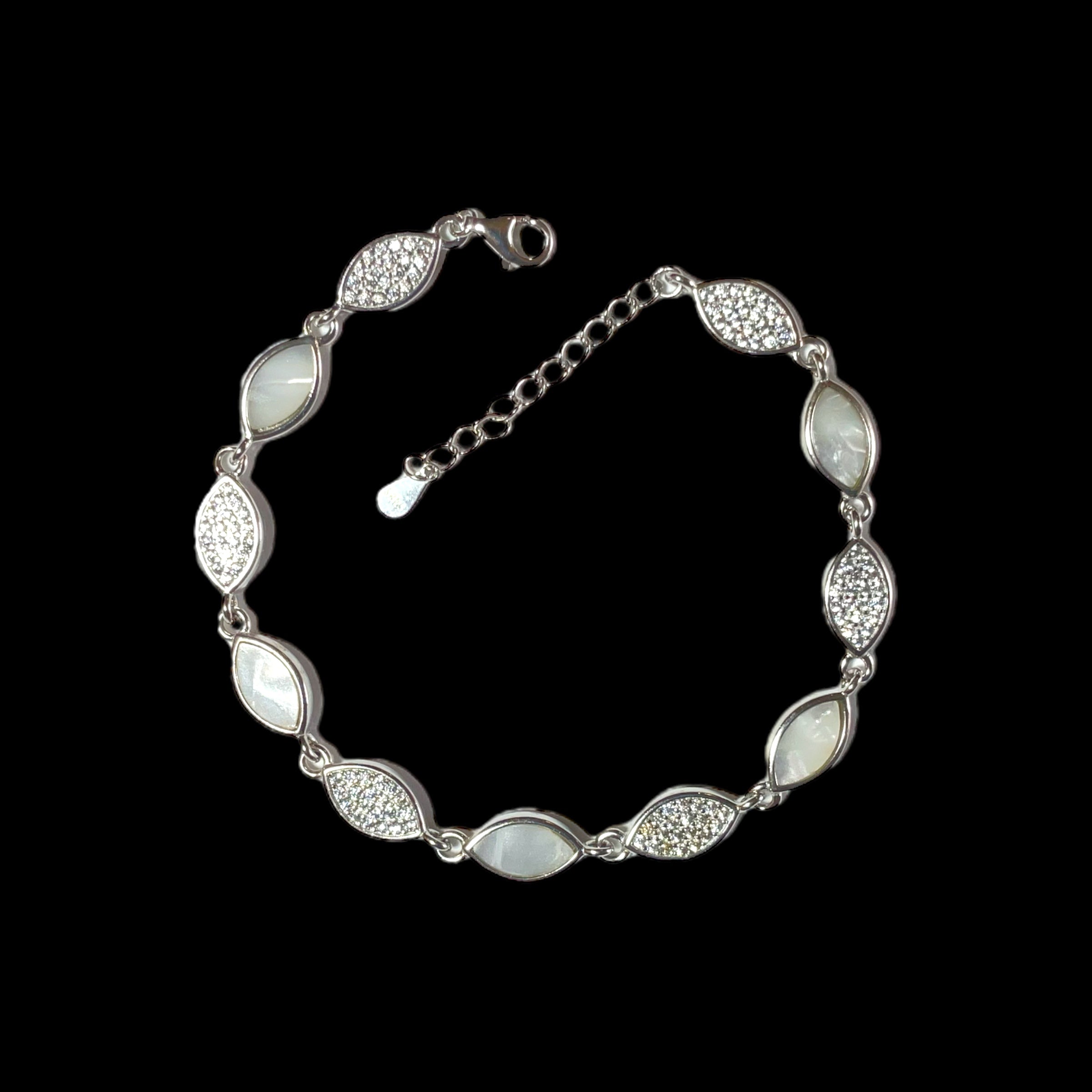a silver bracelet with white stones on a black background