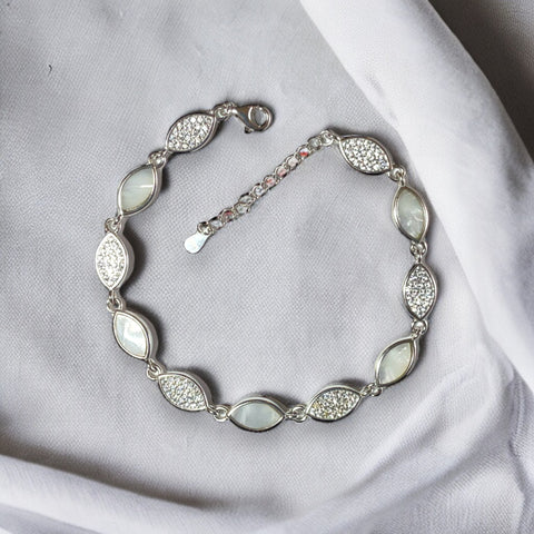 a silver bracelet with white stones on it