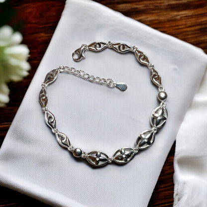 a silver bracelet on a napkin on a table