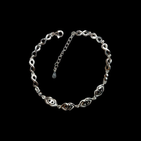 a silver chain bracelet with a heart charm