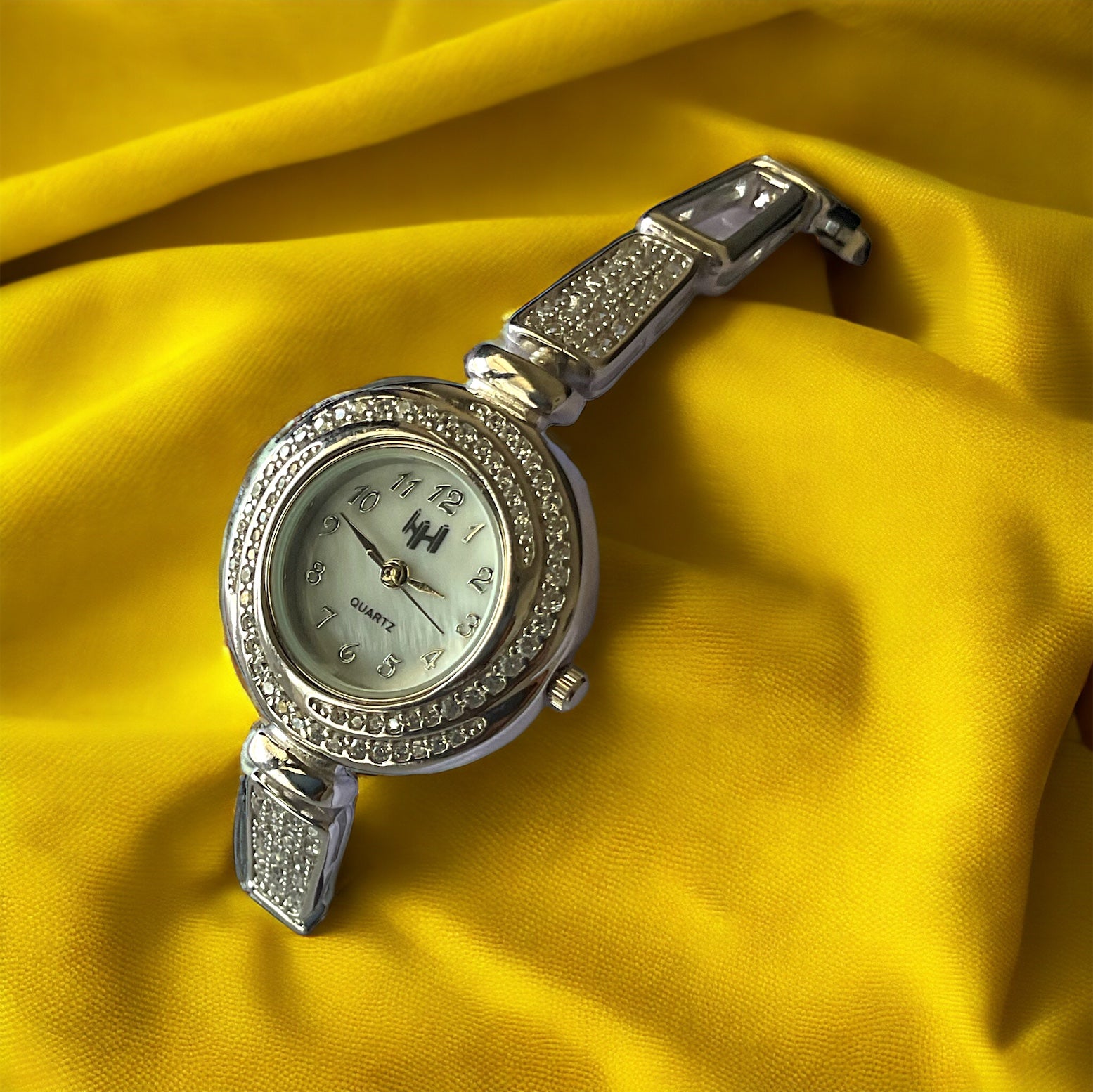 a watch sitting on top of a yellow cloth