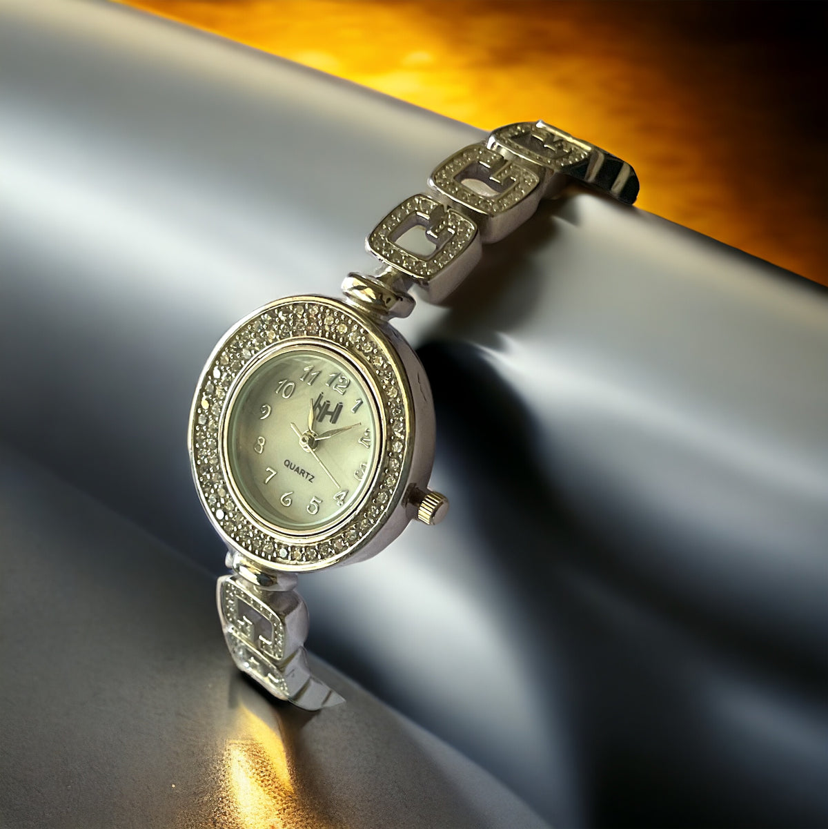 a watch sitting on top of a shiny surface