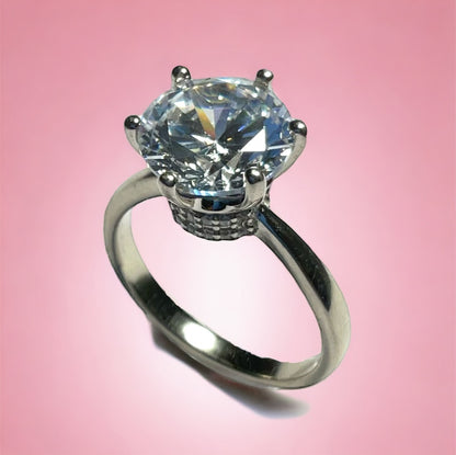 a close up of a diamond ring on a pink background