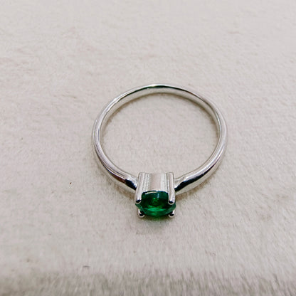 a close up of a ring with a green stone