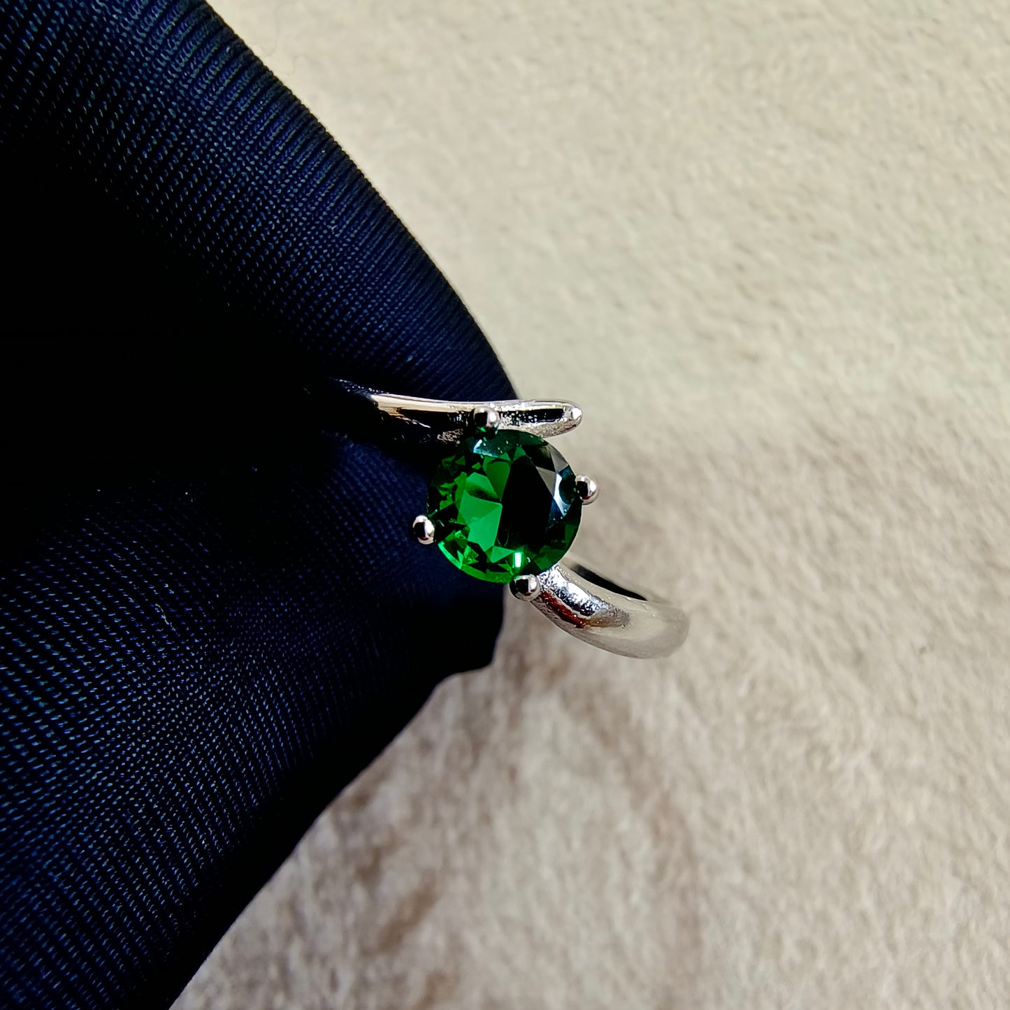 a close up of a ring with a green stone