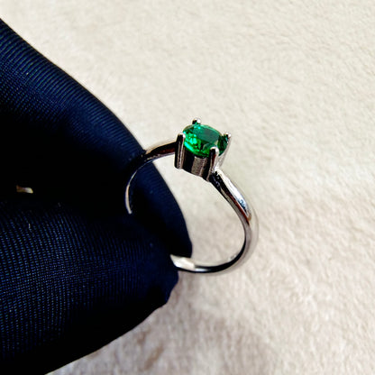 a close up of a ring with a green stone