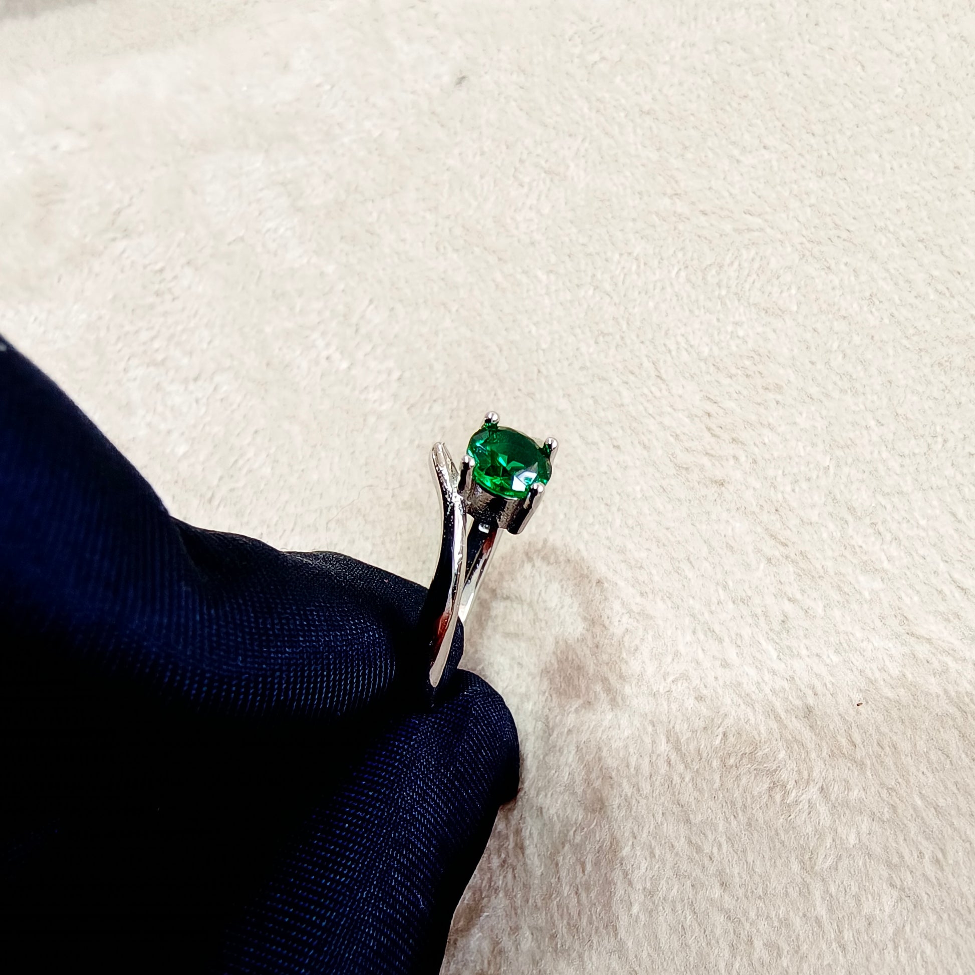 a close up of a ring with a green stone