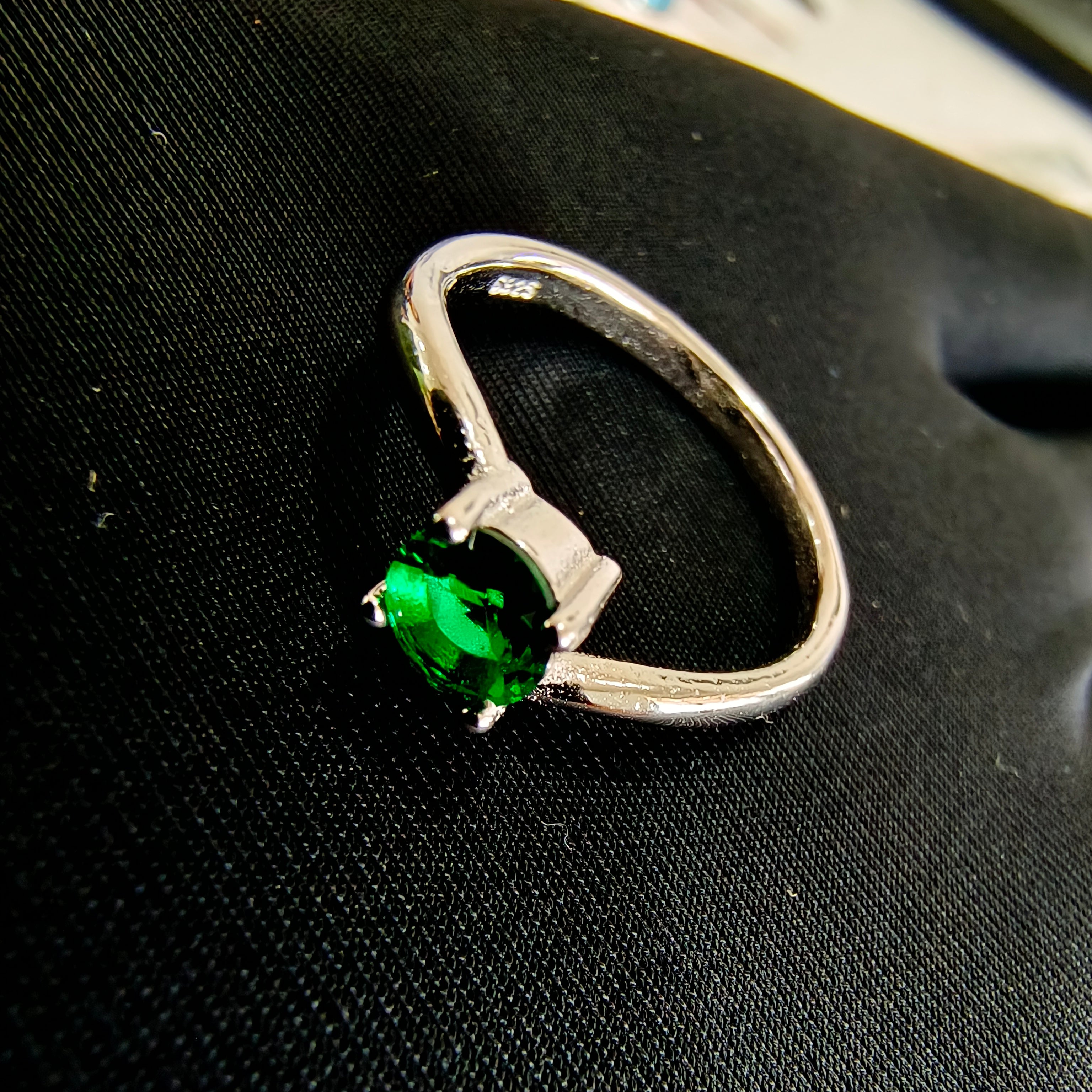 a close up of a ring with a green stone