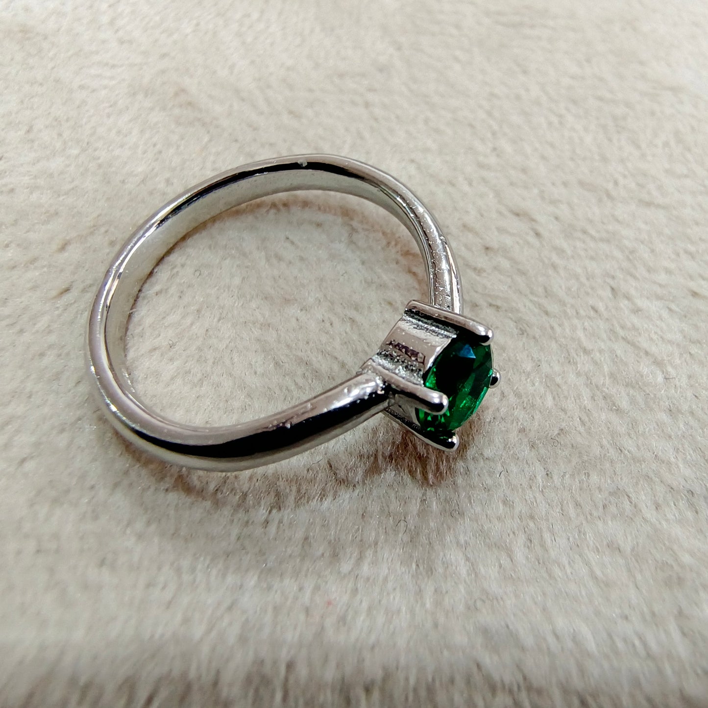 a close up of a ring with a green stone