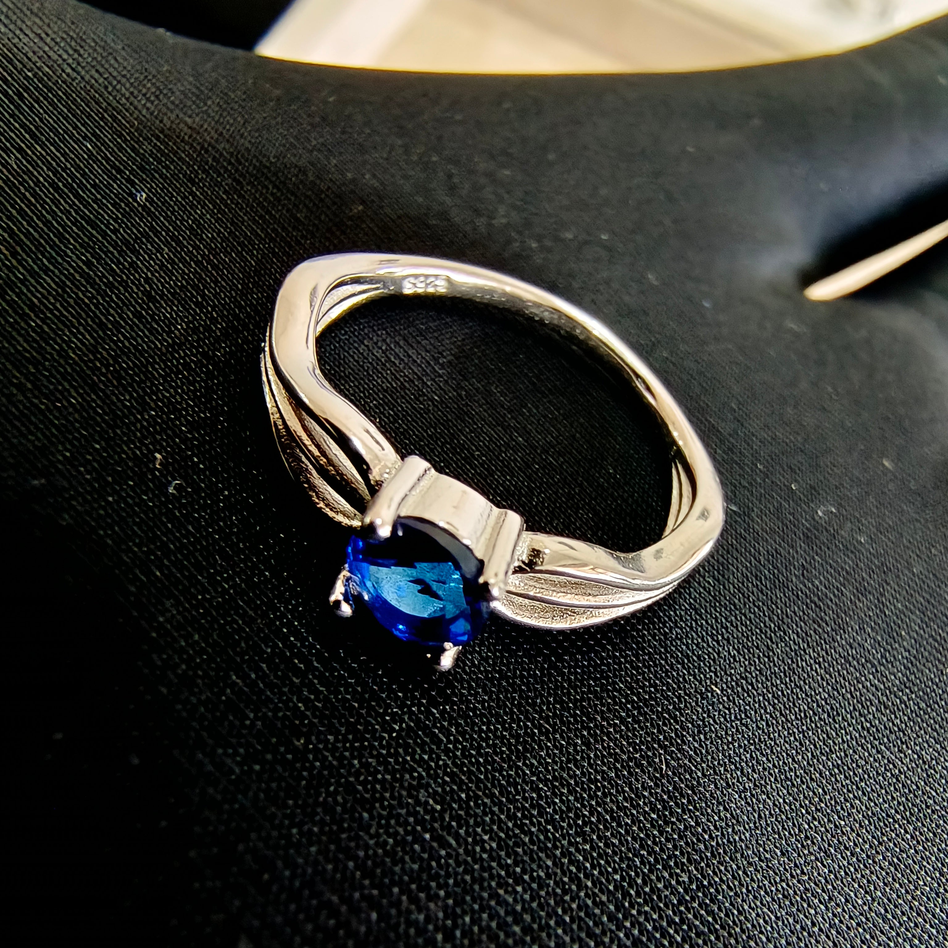 a silver ring with a blue stone on it