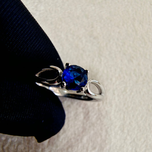 a close up of a ring with a blue stone